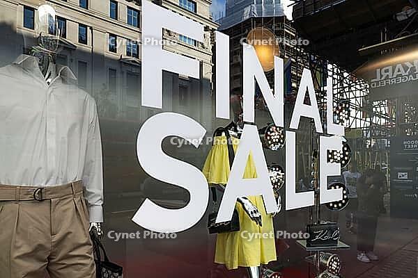 Storefront window of a fashion boutique with a prominent end sale sign with urban street reflections. London, UK, 23. July 2023 [IBR125527098]