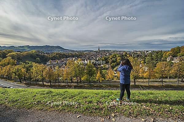 Bern (Berne) Switzerland woman tourist taking photo at old town and Aare River in autumn season [IBR125527109]