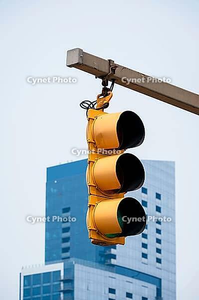 A bright yellow traffic light is visible against a blue modern building in Baltimore, USA [IBR125527119]