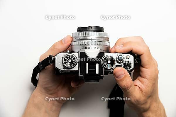 Photographer with camera on white background, close-up of hands and professional photo camera [IBR125536467]