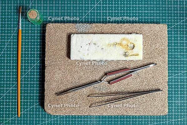 Top view on tools for crafting handmade jewelry on green cutting mat in a workshop [IBR125536485]