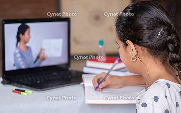 Concept of homeschooling or e-learning, young girls busy writing by using in laptop while teachers explain during covid-19 or coronavirus pandemic crisis [IBR125566004]