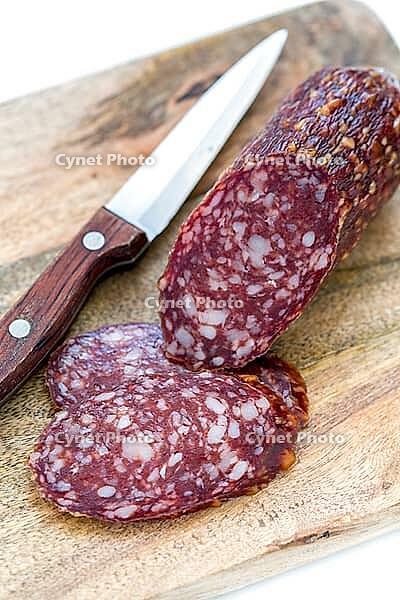 Sliced dry sausage and knife on a white background [IBR125566018]