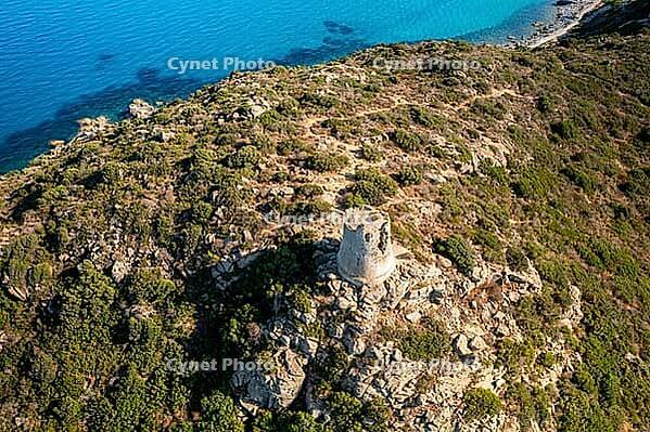 Drone aerial view of a historical Nuraghe tower overlooking the turquoise waters of Porto Giunco beach in Villasimius, Sardinia [IBR125566019]