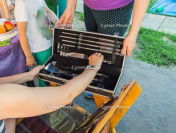 Two woman looking at a luxury barbecue set, in a gift box [IBR125566020]