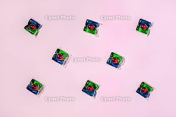 Laundry capsules on light pink background, flat lay. Concept of maintaining cleanliness and hygiene [IBR125566071]