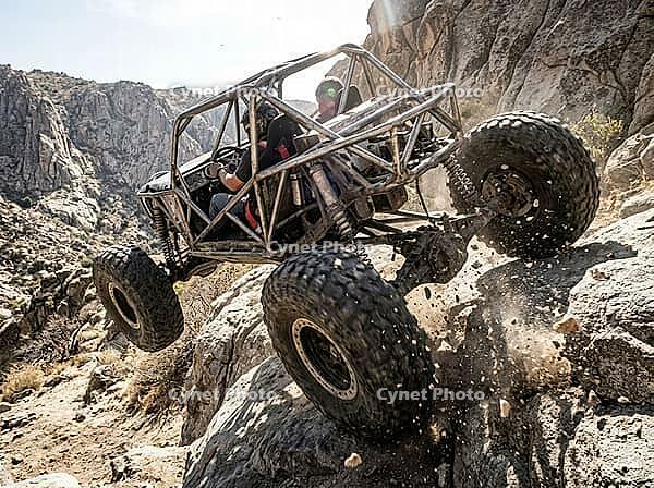 Extreme off road vehicle conquering a challenging rock trail, driver and passenger experiencing the thrill and excitement of a demanding wilderness expedition, AI generated [IBR125592667]