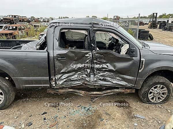 Wrecked gray pickup truck sits in a salvage yard, its side doors crushed, airbags deployed, and chassis bent, illustrating concepts of vehicle damage, collision, and automotive waste, AI generated [IBR125592700]