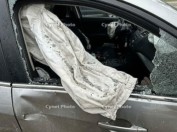 Deployed side curtain airbag billowing through a shattered window on a silver car, showing extensive damage and destruction from a major traffic collision, a reminder of car safety, AI generated [IBR125592701]