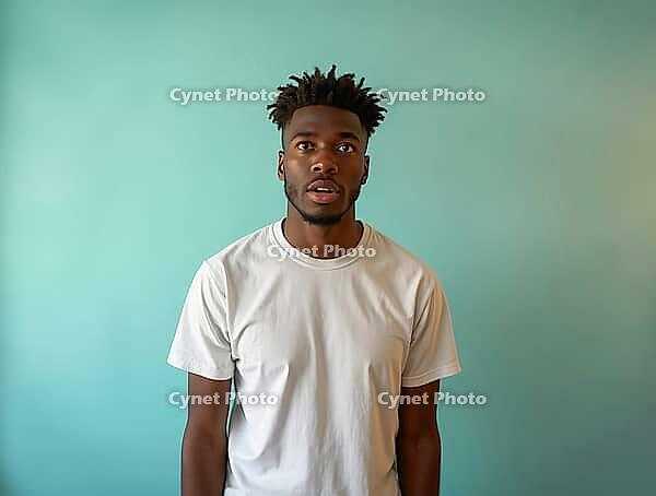 Studio portrait of a surprised young man with dreadlocks wearing a white t-shirt against a light green background, AI generated [IBR125592713]