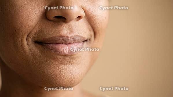 Close-up of adult woman's mouth with lip corners pulled upward in a gentle closed smile, lip corner puller muscle action, cropped face, copy space, AI generated [IBR125592750]