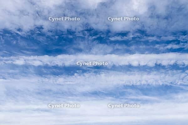 Aircraft condensation contrails in the blue sky inbetween some beautiful clouds [IBR125606076]