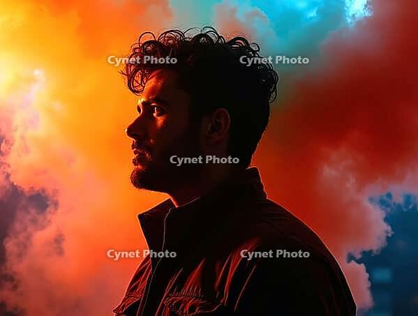 Profile of a young man observing a vibrant and colorful smoke explosion, creating a dramatic and cinematic atmosphere, AI generated [IBR125621297]