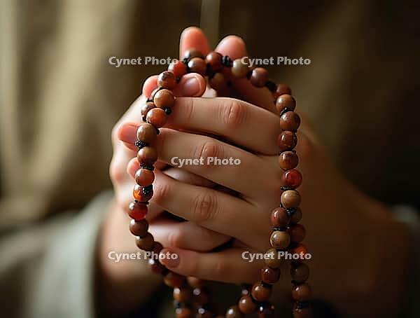 Close-up of hands clasping a rosary in a meditative gesture, AI generated [IBR125621332]