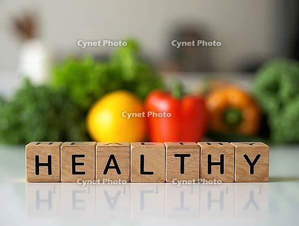 Wooden blocks spelling the word healthy with fresh vegetables in the background promoting a healthy lifestyle, AI generated [IBR125621336]