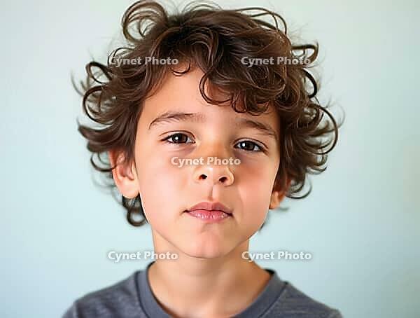 Close-up portrait of a thoughtful young boy with curly hair, conveying a sense of contemplation or uncertainty, AI generated [IBR125621337]