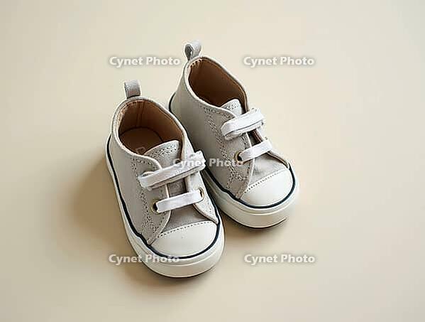 Stylish baby sneakers resting on a neutral backdrop, symbolizing fashion, comfort, and childhood, AI generated [IBR125621358]