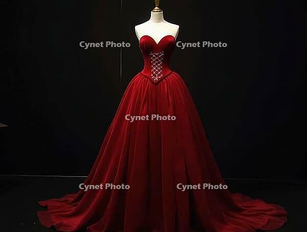 Elegant red velvet gown with a corset bodice displayed on a mannequin against a dark background, perfect for fashion or retail related projects, AI generated [IBR125636900]