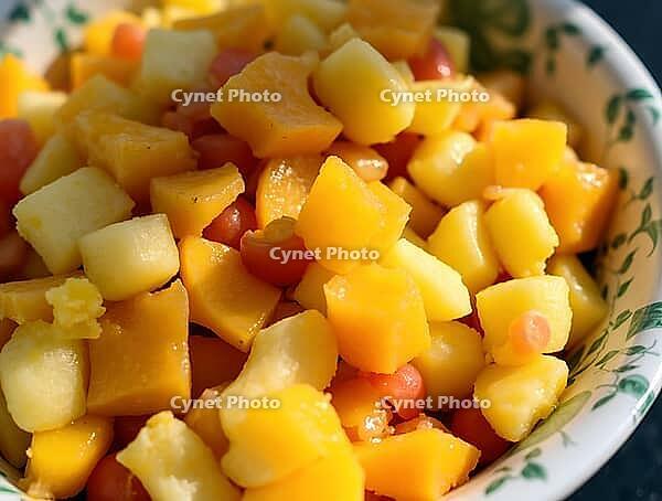 Colorful pieces of fruit salad glistening under sunlight in a bowl, AI generated [IBR125636907]