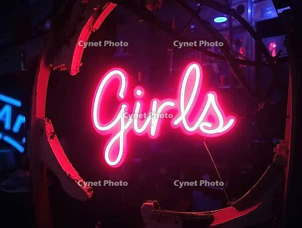 Vibrant neon girls sign glowing at nightclub entrance, creating exciting and seductive atmosphere, AI generated [IBR125636914]