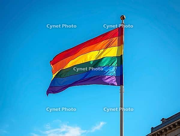 Rainbow flag waving in the wind against a clear blue sky, representing LGBTQ+ pride, diversity, and inclusion, AI generated [IBR125636915]