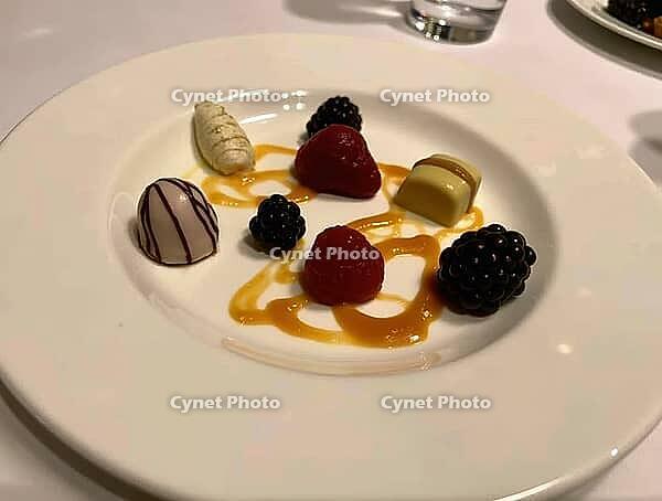 Exquisite dessert plate featuring assorted pralines, fresh berries, and a drizzle of caramel sauce, creating a luxurious culinary experience, AI generated [IBR125636916]