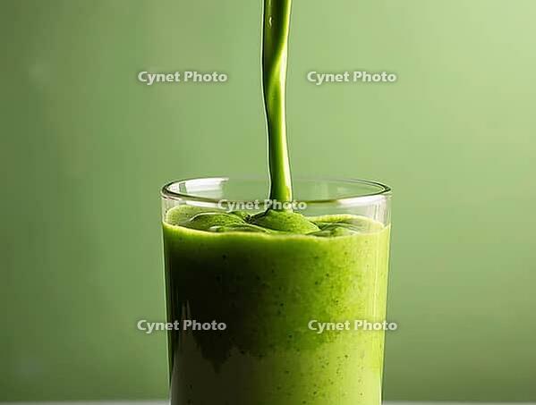 Pouring nutritious green smoothie into glass on green background: health and wellbeing concept, AI generated [IBR125636918]