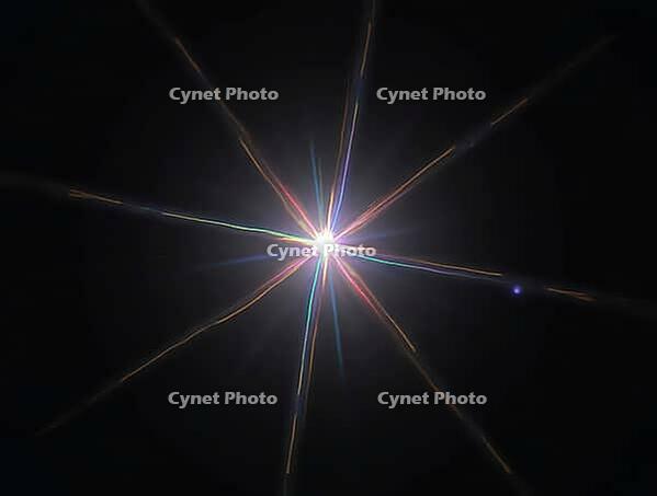 Colorful light rays emanating from a central bright spot creating a star-like effect against a dark backdrop, AI generated [IBR125636942]