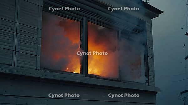 Intense fire burning inside a house, with flames and smoke billowing out of a window, creating a dramatic scene of destruction, AI generated [IBR125653408]