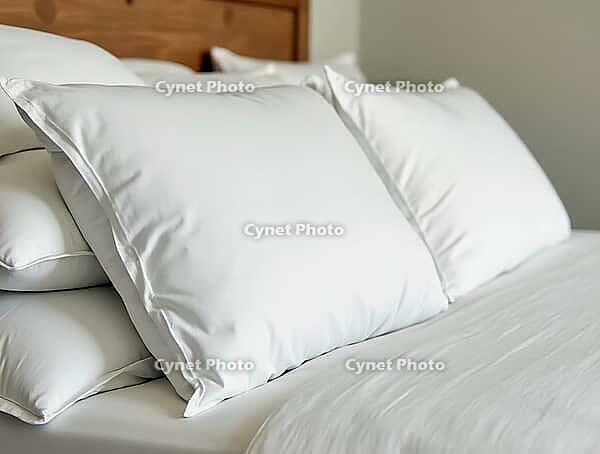 Freshly made bed with fluffy white pillows and tucked-in sheets creates a welcoming and comfortable atmosphere, AI generated [IBR125653412]