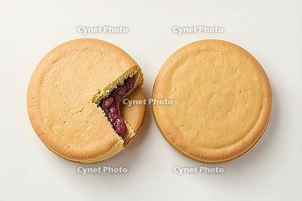 Round golden stamped cakes with one halved to show filling, Imagawayaki, Wheel cake with bean paste, batter and red bean paste, Tokyo, Kantō, Japan, dessert, confectionery, food photography, AI generated [IBR125653442]