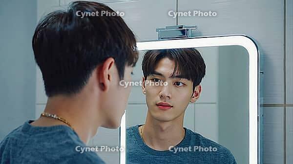 Young man admiring his reflection in a sleek, modern bathroom mirror while focusing on grooming and enhancing his appearance, AI generated [IBR125653452]