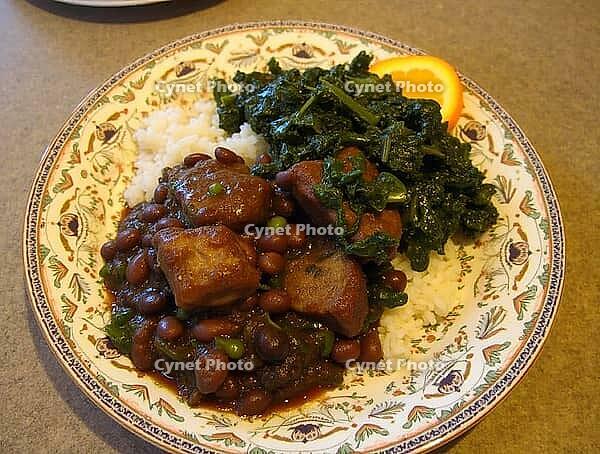 Traditional brazilian feijoada served with rice, collard greens, and orange slices, offering a vibrant culinary experience, AI generated [IBR125653464]