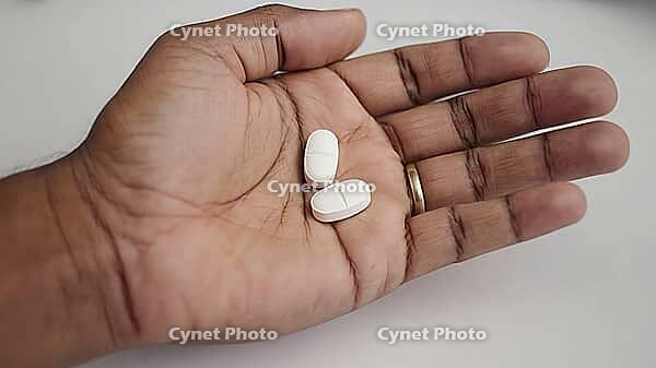 Open hand displaying two white pills, representing a concept of medical treatment and healthcare in a clinical setting, AI generated [IBR125653476]