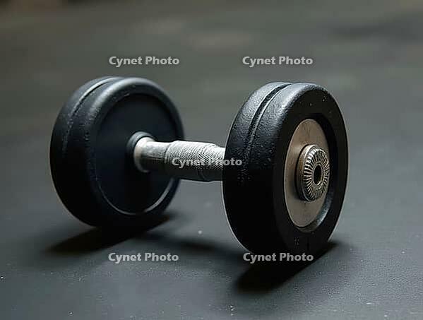 Heavy black dumbbell lying on gym floor, suggesting a challenging workout session focused on strength and fitness, AI generated [IBR125653489]