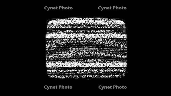 Close up shot of an analog television displaying static noise flickering screen monochrome grain and interference patterns creating a vintage glitchy chaotic visual texture useful as background [IBR125654771]