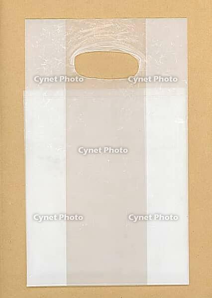 Transparent plastic bag over light brown background [IBR125654845]