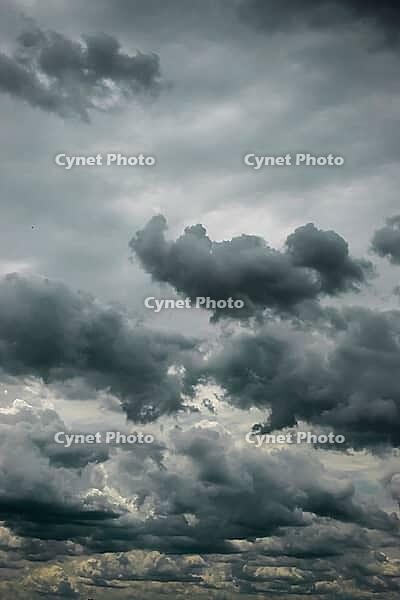 Towering dark clouds rise above a dense, layered gray cloudscape in a brooding sky [IBR125657386]