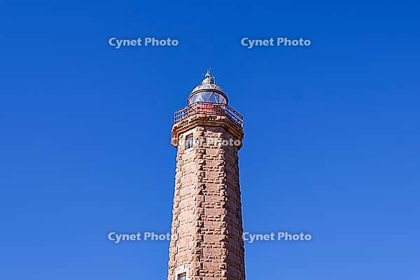 A stone lighthouse rises against a clear, deep blue sky, Estepona, Costa del Sol, Andalusia, Malaga province, Spain [IBR125657393]
