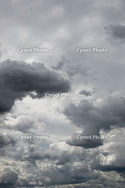 Towering dark and pale gray clouds fill the sky in a dramatic, densely layered cloudscape [IBR125657399]