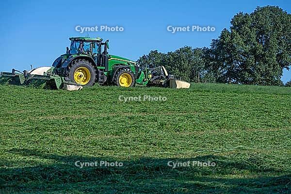 Tractor and large mower of the Köchesldorf agricultural cooperative mowing grass, Othenstorf, Mecklenburg-Western Pomerania, Germany [IBR125657402]