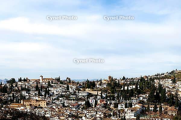 The roofs and houses of Granada stretch over a rolling hill under a bright sky, view from the Alhambra, Alhambra, Granada, Province of Granada, Andalusia, Spain [IBR125657420]