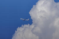 積乱雲をバックに飛ぶJALの飛行機 [XEL110002491]