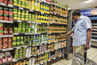 Pick n Pay grocery store shelves display canned vegetables man shopping [UIG110171049]