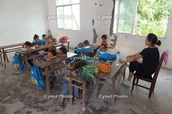 The most arduous sleep: Mountain village students napping at their desks. [IMC111460083]