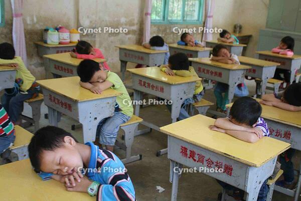 Suichuan, Jiangxi: Elementary school students in mountainous areas nap with their backs hunched over their desks. [IMC111460098]