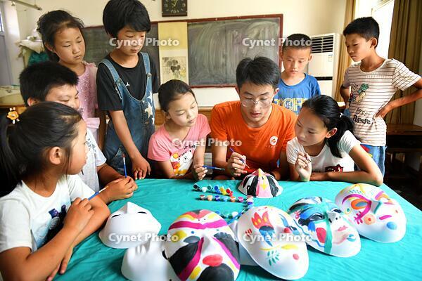 Zaozhuang, Shandong: Students from Shandong University of Science and Technology volunteer as teachers and interact happily with children. [IMC111460104]